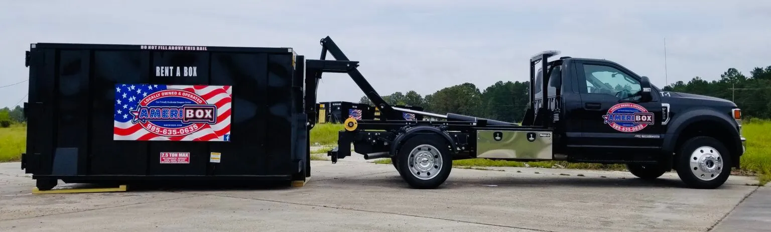 A picture of a dumpster truck delivering a dumpster to a parking lot in Mandeville, LA.